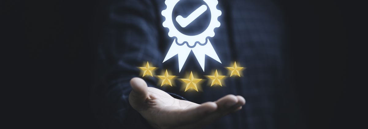 Success: hand holding a digital badge with a checkmark above five gold stars, symbolizing quality or excellence.